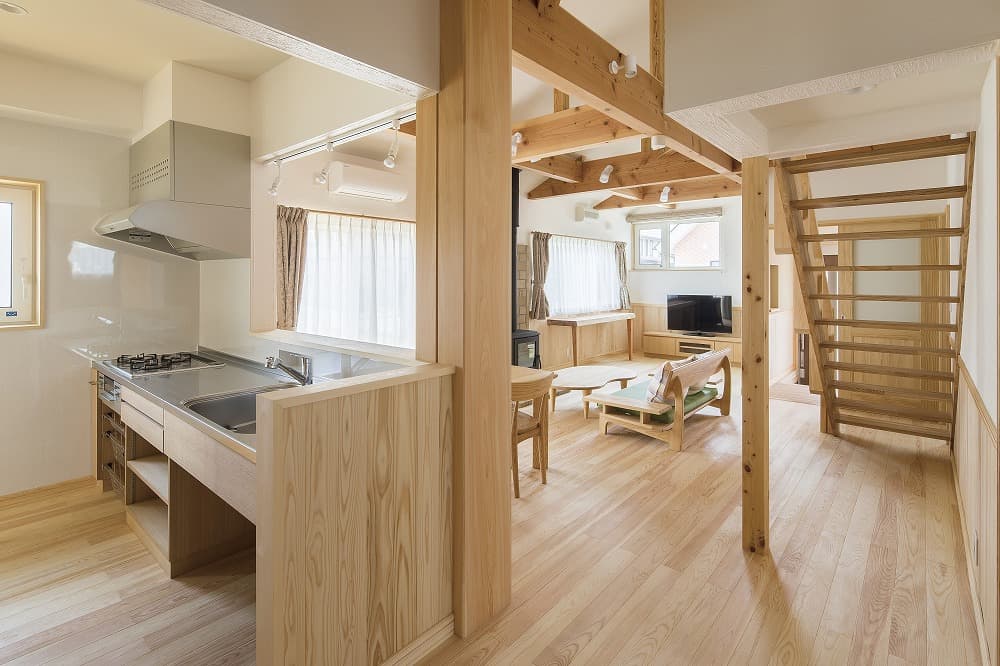 ステンレスキッチンと木製階段が調和する、平屋の開放空間