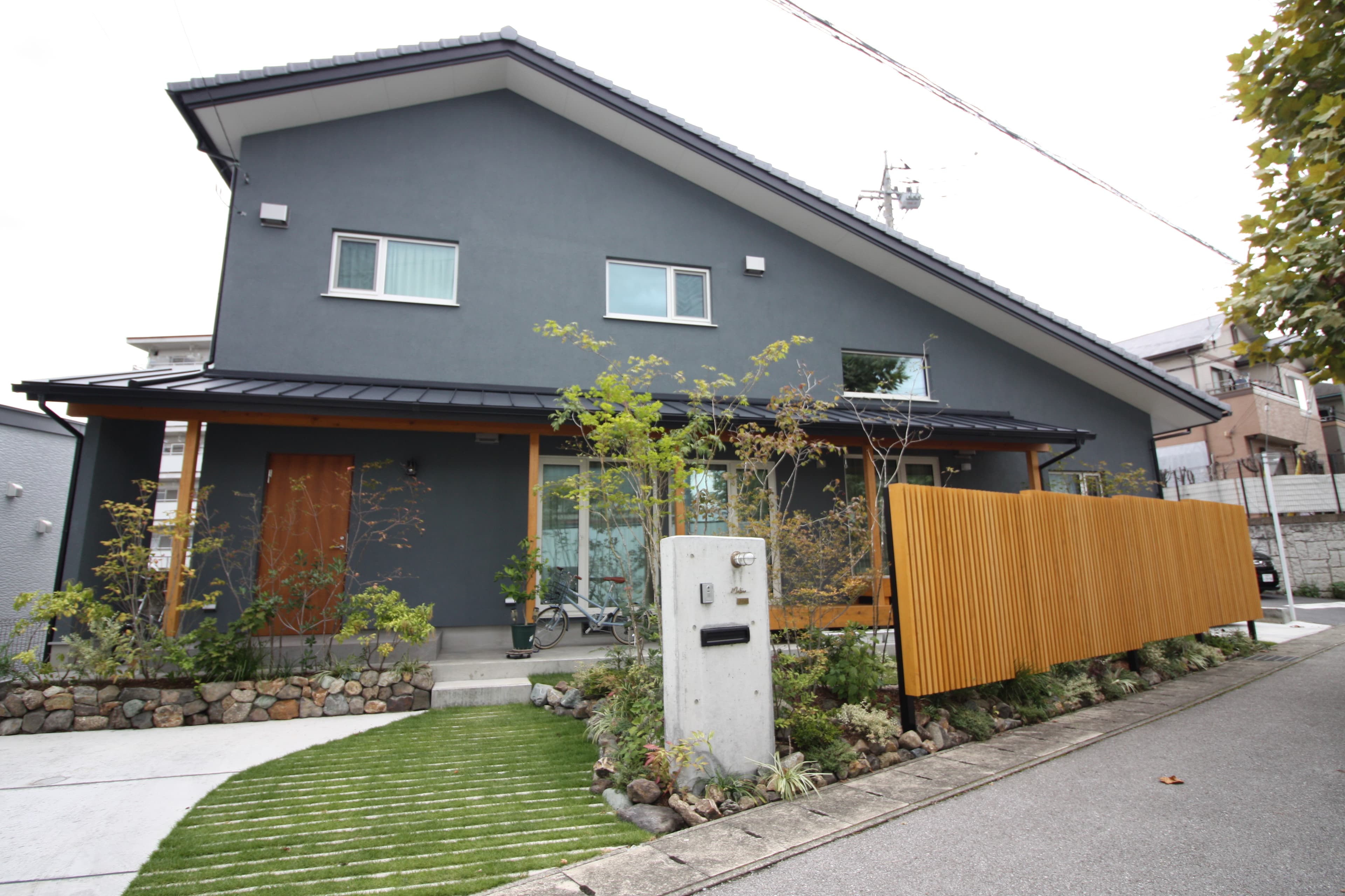 木製の縦格子フェンスと門柱が印象的なデザインx省エネルギー性能の家