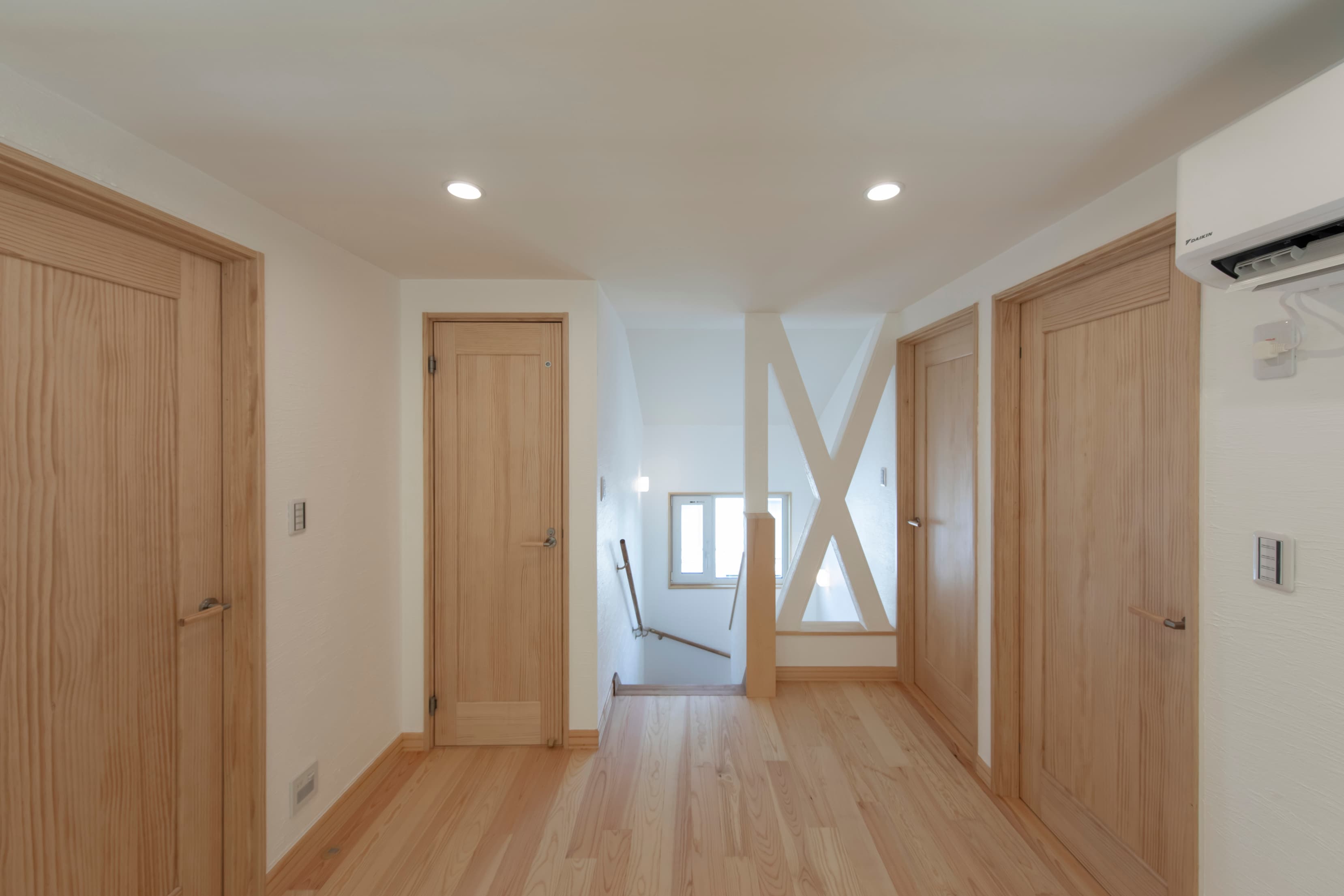 木製の腰壁とデスクが一体となった明るいワークスペースのある家