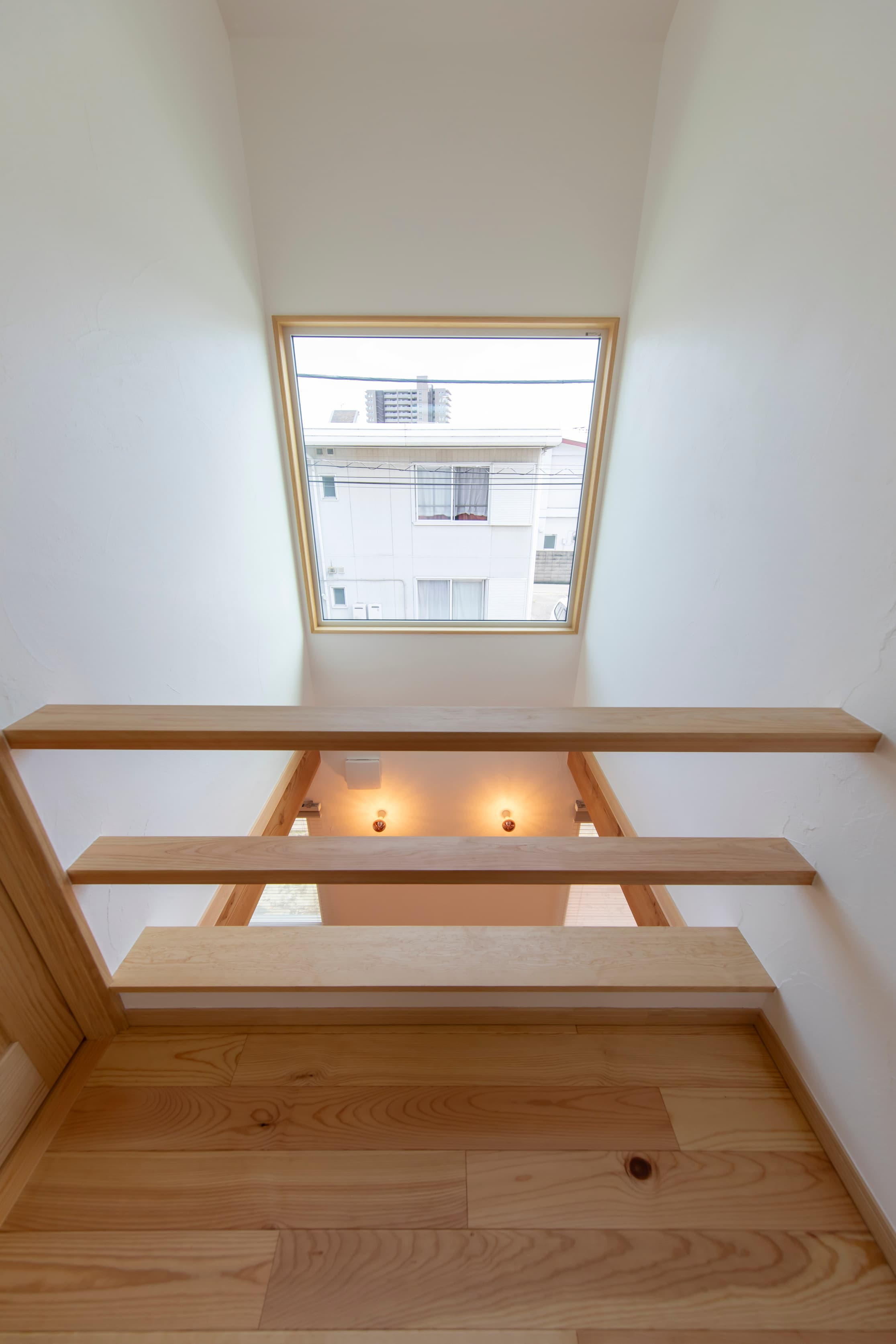 浮遊階段と天窓が生む光と影が織りなす空間の家